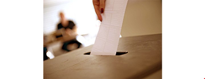 Fotografi av en stemmeseddel som legges i valgurnen